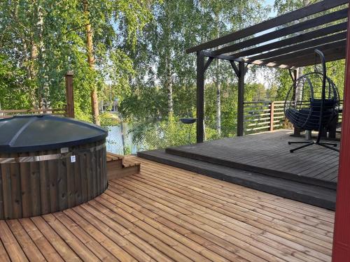 una terrazza in legno con panca e altalena di Luksushuvila louhosjärven rannalla a Isokyrö