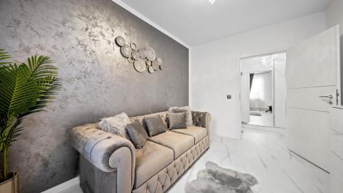 a living room with a couch and a wall at RT Luxury Royal Residence in Braşov