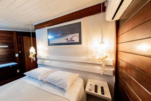 Un pequeño dormitorio con una cama y una mesa. en Pôr do Sol Ilha do Mel Pousada e Receptivo, en Ilha do Mel