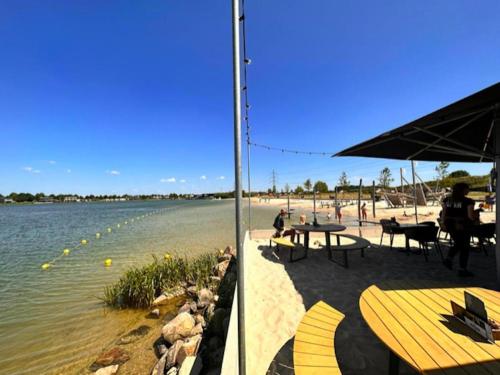 a beach with tables and chairs next to the water at De Berk in Zuidwolde