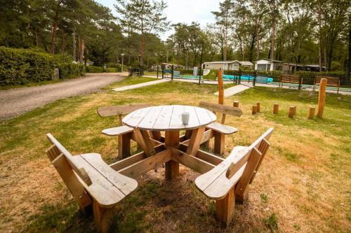 a picnic table and two benches in a park at De Berk in Zuidwolde