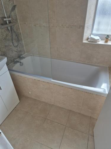 La salle de bains est pourvue d'une baignoire blanche et d'une fenêtre. dans l'établissement Eco House Brighton & Hove, à Brighton et Hove