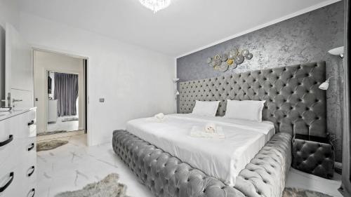 a bedroom with a large bed with a large headboard at RT Luxury Royal Residence in Braşov