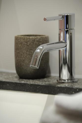 a bathroom sink with a chrome water faucet at Hotel Astoria Gent in Ghent