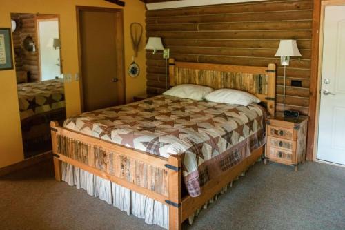 a bedroom with a bed in a log cabin at HONEYSUCKLE - Rustic cabin for 2 in Oak Creek Canyon in Indian Gardens
