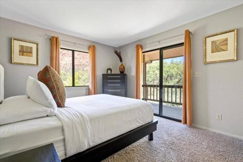 a bedroom with a large bed and a balcony at Kaibab - Adobe Village condo - 2 bedroom in Oak Creek
