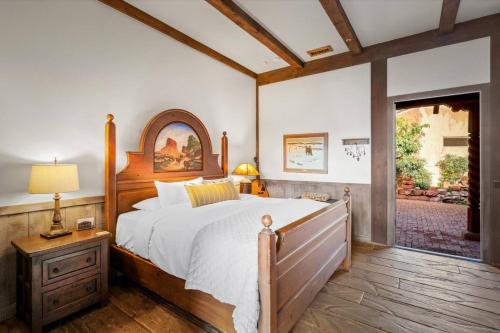 ein Schlafzimmer mit einem großen Bett mit Holzrahmen in der Unterkunft Adobe Village Villa- Lonesome Dove in Oak Creek