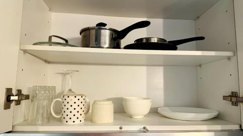 a shelf with pots and pans and other kitchen items at Scarletz suites klcc Twin Tower by ESD in Kuala Lumpur