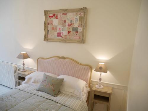a bedroom with a bed with two lamps and a picture on the wall at L'Arbre D'Ange in Montmorillon