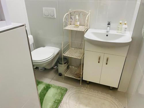 een witte badkamer met een wastafel en een toilet bij Wild Olive at 51 in Windhoek