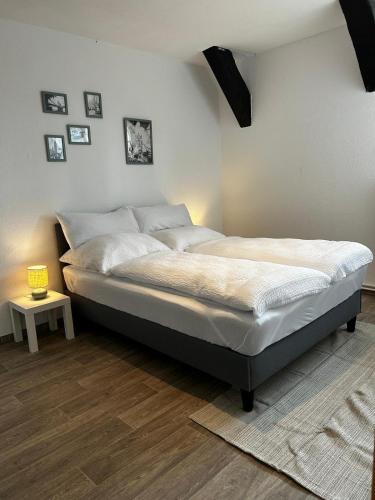 a bedroom with a bed in a room with a table at Apartment London in Bergen an der Dumme
