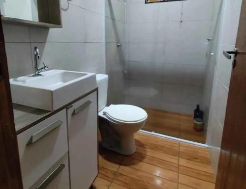 a bathroom with a toilet and a sink and a shower at Hospedaje Vildumar in Pichilemu