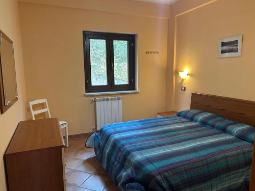 a bedroom with a bed and a table and a window at La Piccola Stella in Castel del Giudice
