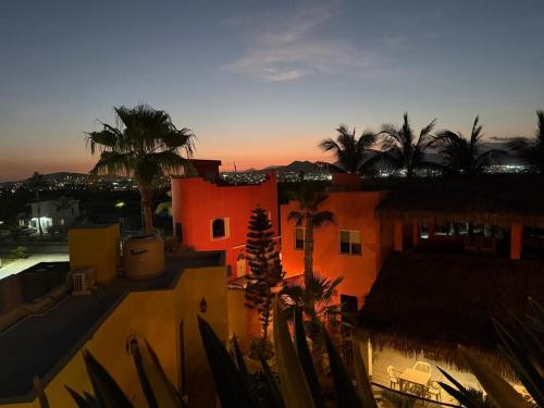 a view of a building with palm trees at sunset at Posada Nomad in San José del Cabo