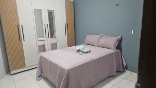 a bedroom with a bed with a pink blanket and mirrors at Sítio Menezes in Parnaíba