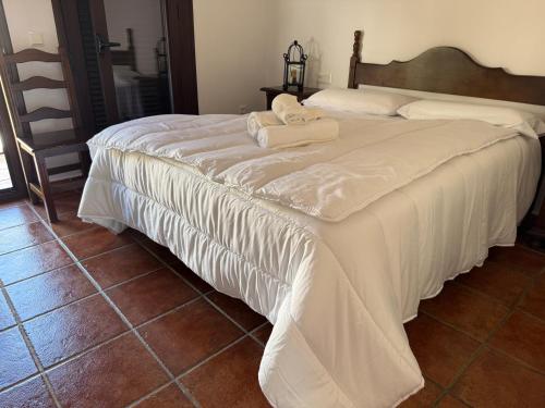 ein großes weißes Bett mit zwei Handtüchern darauf in der Unterkunft Hotel Restaurante Atalaya in Comares