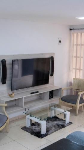 カリにあるHermosa casa en caliの壁に薄型テレビが取り付けられたリビングルーム