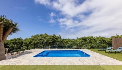 Una piscina en un patio con dos sillas. en Casa Mágica piscina privada, en La Esquinita