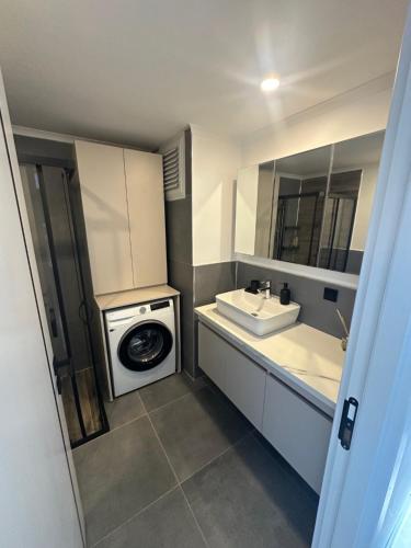 a bathroom with a washing machine and a sink at Charmante, moderne Wohnung 10 Minuten Fußweg zum Strand! in Side