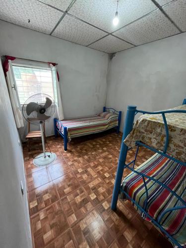 Zimmer mit 2 Etagenbetten und einem Ventilator in der Unterkunft Casa "La Paskana" - Descanso y naturaleza en el Cadillal in Tafí Viejo