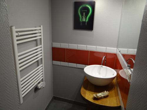 baño con lavabo y luz verde en la pared en Aux oiseaux de passage en Rosheim