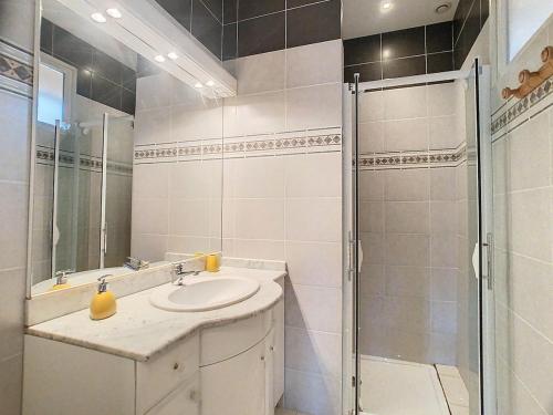 een witte badkamer met een wastafel en een douche bij Cocon cosy au cœur des Pyrénées in Campan