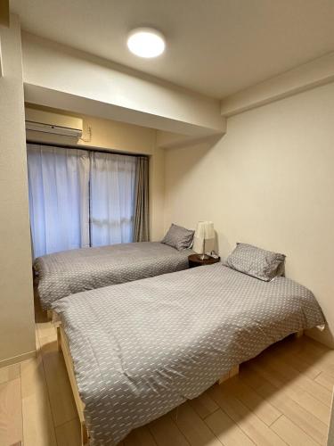 zwei Betten in einem Zimmer mit Fenster in der Unterkunft # 3 Katsu House日本桥地铁站6分 in Wada