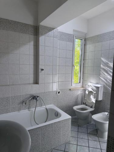 a bathroom with a tub and a toilet and a sink at Spazioso appartamento 2 in Tortona