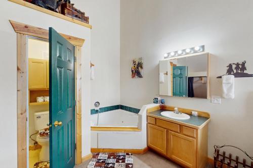a bathroom with a sink and a blue door at Saddle Peak Outpost- Unit A & B in Belgrade