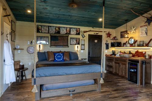 a bedroom with a bed suspended from a ceiling at "Land of the Free, Home of the Brave" Double Luxury Treehouse for 12 Near Dollywood & Pigeon Forge in Catlettsburg