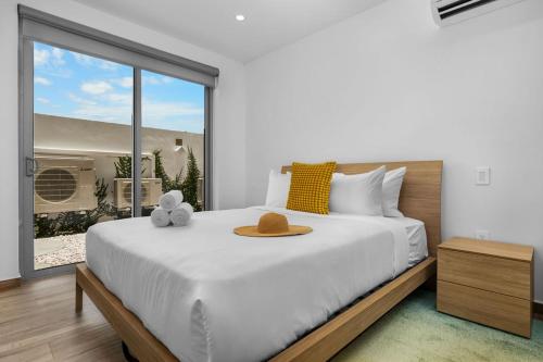 a bedroom with a large bed with a hat on it at Modern Studio w/ Pool, Gym & Rooftop Palm Beach in Palm-Eagle Beach