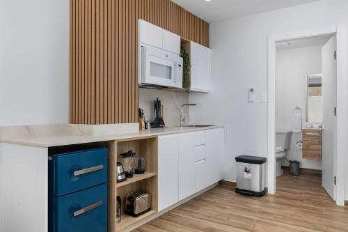 a kitchen with white cabinets and a blue drawer at BRAND NEW Studio w/Pool, GYM, Rooftop @ Palm Beach in Palm-Eagle Beach