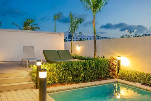 a swimming pool with a bench next to a building at BRAND NEW Studio w/Pool, GYM, Rooftop @ Palm Beach in Palm-Eagle Beach