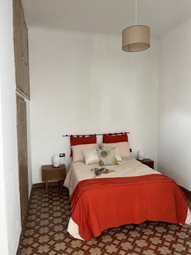 a bedroom with a large bed with a red blanket at Las Marias in San Fernando del Valle de Catamarca