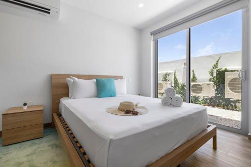 a bedroom with a bed with a hat and a window at NEW Modern Studio w/ Pool & Gym I Walk 2 PalmBeach in Palm-Eagle Beach