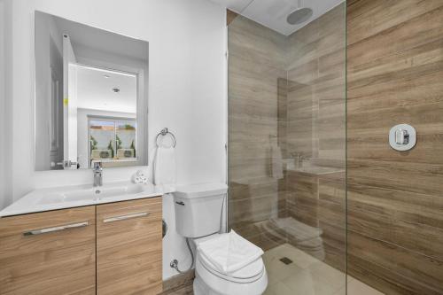 a bathroom with a toilet and a sink and a shower at NEW Modern Studio w/ Pool & Gym I Walk 2 PalmBeach in Palm-Eagle Beach