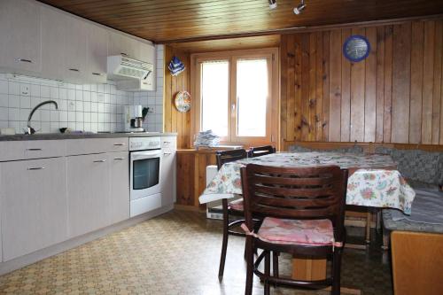 eine Küche mit einem Tisch, einem Tisch und Stühlen in der Unterkunft Chalet Talblick in Saas-Grund