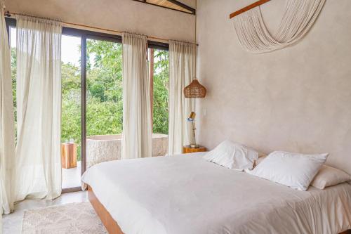 a bedroom with a white bed and a large window at Casa Oasis in San Luis