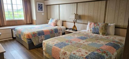a hotel room with two beds and a window at Patti's Inn and Suites in Grand Rivers