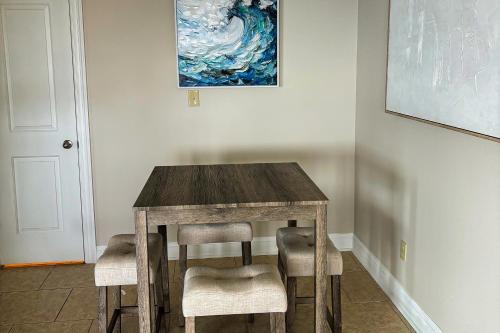 a wooden table with chairs and a painting on the wall at The Sound at Seaglade in Seaglades