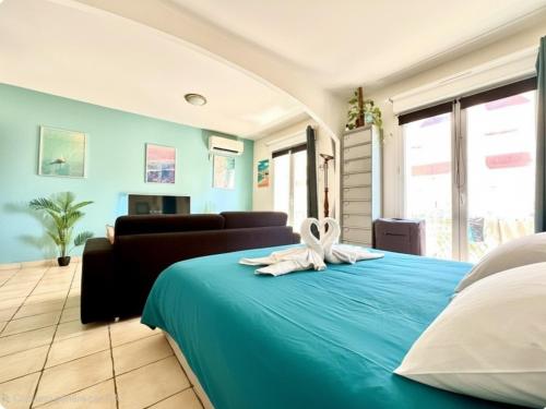 a bedroom with a blue bed with a towel on it at LE COSY Canet - Studio pour 2 personnes à 30m de la plage avec parking in Canet-en-Roussillon