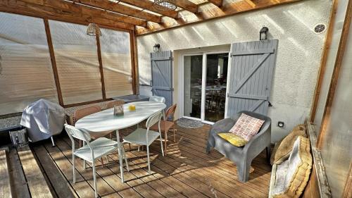 - une terrasse couverte avec une table et des chaises dans l'établissement Le clos du bon temps, à Sainte-Marie-de-Vaux