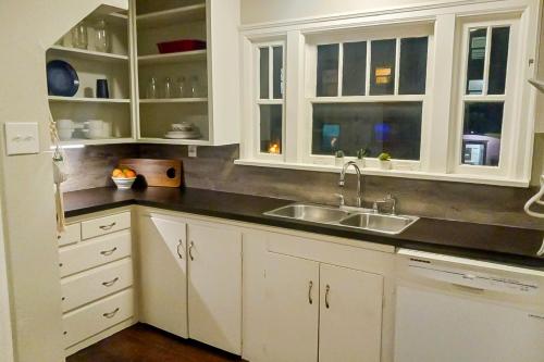 a kitchen with white cabinets and a sink at The Jul on State in Bremerton