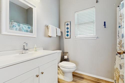 a white bathroom with a toilet and a sink at Gulf Breeze in Rockport