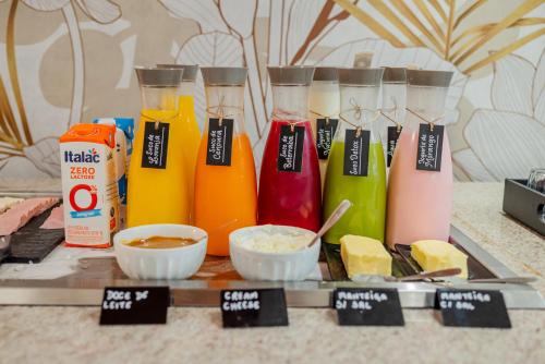 un ensemble de bouteilles d'aliments de couleurs différentes sur un plateau dans l'établissement Ibis Styles Campinas Alphaville, à Campinas