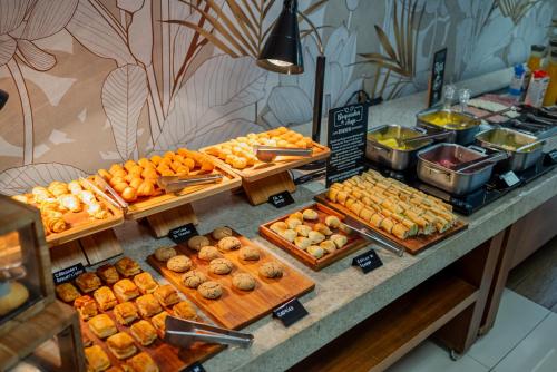 un buffet de beignets et autres pâtisseries exposé dans l'établissement Ibis Styles Campinas Alphaville, à Campinas
