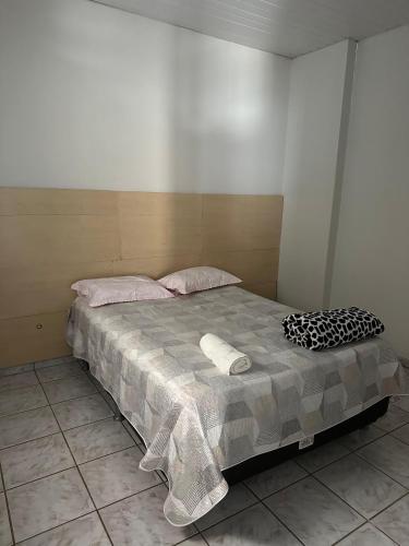 a bed with two pillows on it in a room at Casa no centro in Mineiros