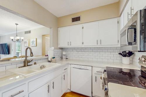 eine Küche mit weißen Schränken und einer Spüle in der Unterkunft The Palm Collection in Marco Island