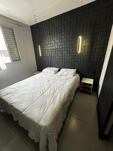 a bedroom with a white bed with a brick wall at Modern Apartment in São Caetano do Sul in São Caetano do Sul