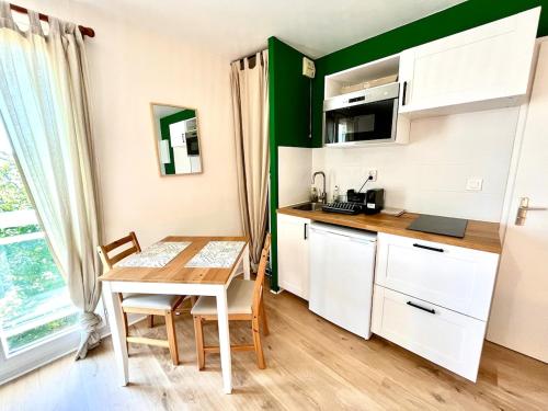 cocina con mesa y cocina pequeña con mesa y sillas en Cocooning appartement, en Joué-lès-Tours